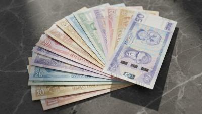 Editorial flat-lay of an abstract fan of multiple currency notes on polished dark stone, soft directional daylight