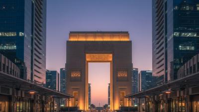 Iconic trapezoidal Gate Building of DIFC at twilight with the Gate Avenue promenade and surrounding glass towers