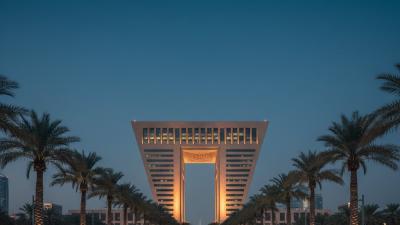 Iconic trapezoidal Gate Building of DIFC at blue hour with the Gate Avenue pedestrian promenade in the foreground
