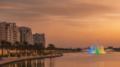 Al Majaz waterfront residential buildings and lagoon promenade in warm evening light