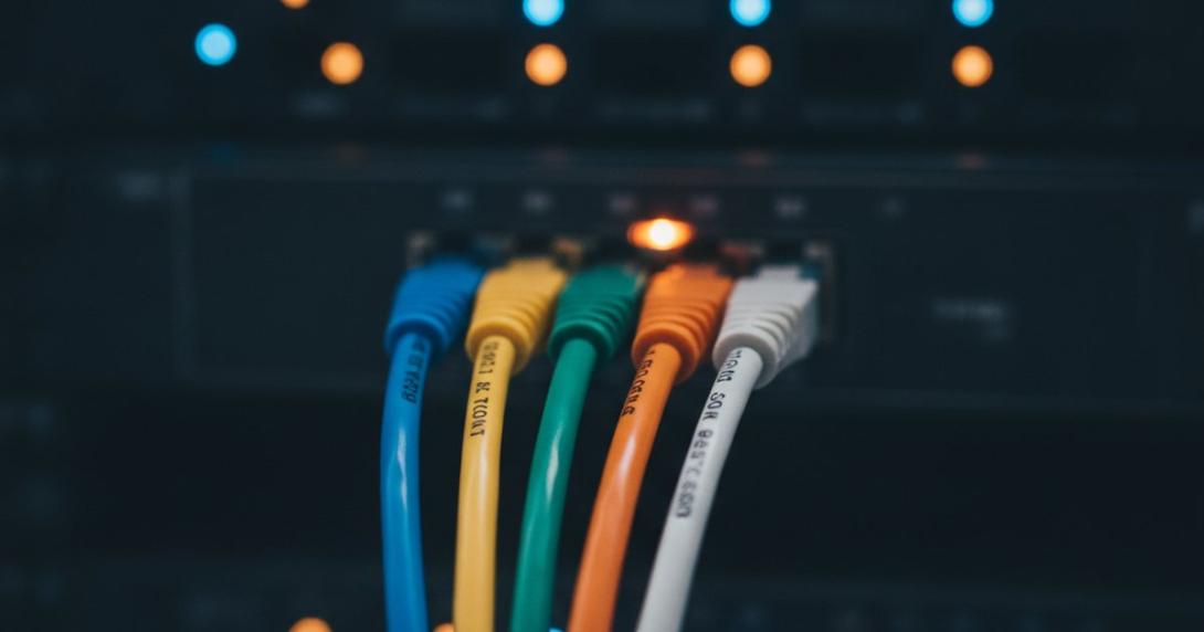 Five coloured network cables converging into one glowing switch port — the UAE e-invoicing five-corner model